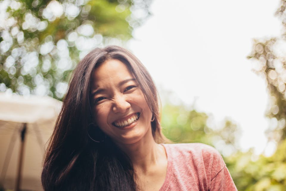 Happy middle-aged woman with long dark hair smiling at the camera.